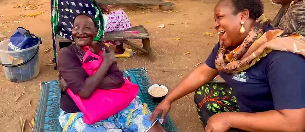 An elderly woman laughing with a volunteer