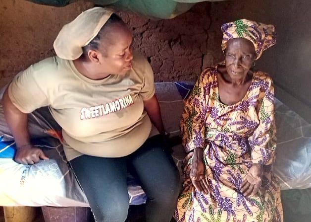 A volunteer sitting and talking with an elderly woman in her home