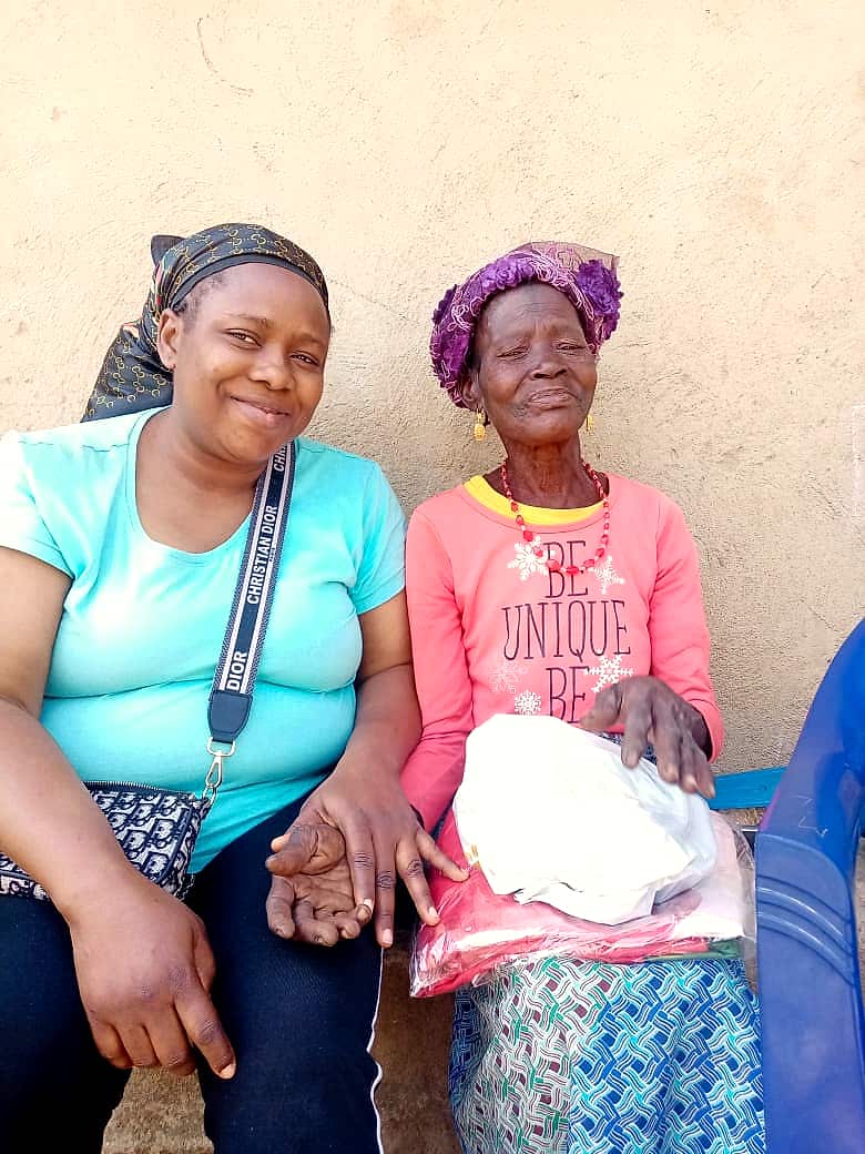 A volunteer handing a food pack to an elderly woman