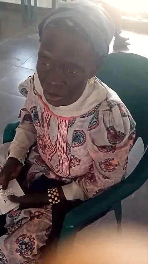 An elderly woman smiling at an outreach